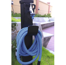 Wasserzapfstelle für den Garten mit flexiblem Gartenschlauch und Wasserhahn an einer schwarzen Säule.