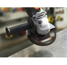 Winkelschleifer mit rotierender Trennscheibe bei der Bearbeitung einer Metallkante in einer Werkstatt.