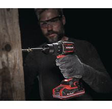 Ein Mann schraubt mit einem Einhell Akku-Schlagbohrschrauber eine Schraube in einen Holzbalken.