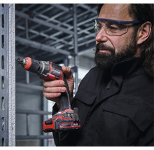 Einhell Akku-Trockenbauschrauber in Verwendung an einem Metallständerwerk durch eine Person mit Schutzbrille und Gehörschutz.