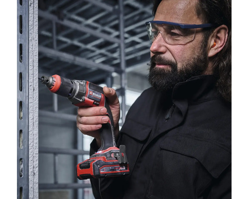 Einhell Akku-Trockenbauschrauber in Verwendung an einem Metallständerwerk durch eine Person mit Schutzbrille und Gehörschutz.