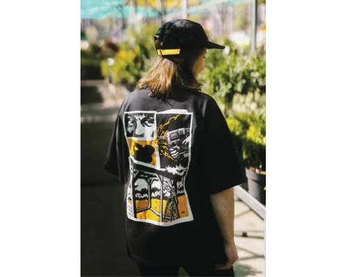 Schwarzes T-Shirt mit Comic-Grafik auf dem Rücken, die handwerkliche Tätigkeiten wie Bohren und Holzbau darstellt.