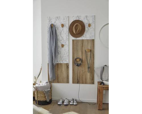 Moderne Garderobenpaneele in Marmor-Optik und Holzdekor mit hölzernen Wandhaken in einem hellen Eingangsbereich.