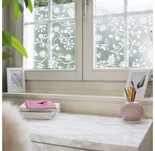 Sichtschutzfolie für Fenster mit floralem Rankenmuster in Weiß auf mattem Grund, dekorative Fensterfolie in hellem Raum.