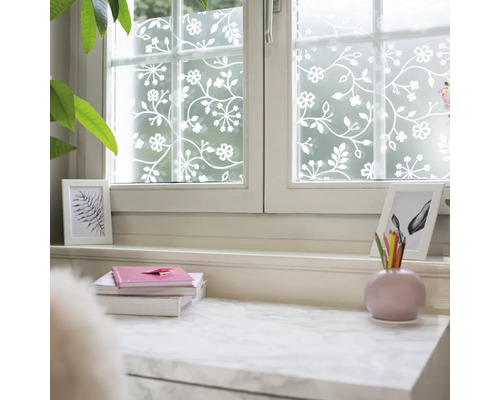 Sichtschutzfolie für Fenster mit floralem Rankenmuster in Weiß auf mattem Grund, dekorative Fensterfolie in hellem Raum.