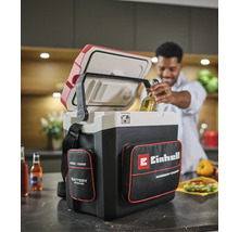 Einhell Power X-Change Akku-Kühlbox mit Zubehörtaschen in einer Küche, ein Mann entnimmt eine Getränkeflasche aus der geöffneten Box.