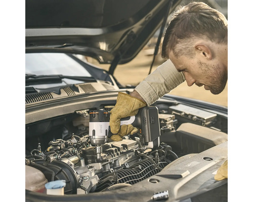 Ein Mann verwendet einen Litheli Akku-Schlagschrauber zur Arbeit an einem Automotor bei geöffneter Motorhaube.