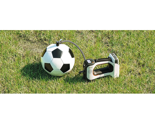 Tragbare elektrische Luftpumpe Litheli beim Aufpumpen eines Fußballs auf einer Rasenfläche.