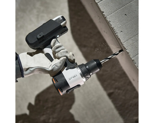 Akkubohrschrauber von Litheli bohrt in einen Betonblock, Hand mit Arbeitshandschuh hält das Gerät.