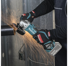 Eine Person nutzt einen Makita Akku-Winkelschleifer mit 18 Volt Akku an einem Metallrohr, während Funken fliegen.