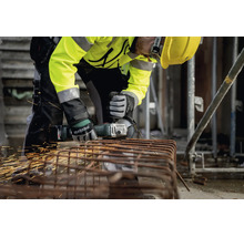 Handwerker mit Metabo Akku-Winkelschleifer schneidet Metallbewehrung auf einer Baustelle, Funkenflug, Sicherheitsausrüstung.