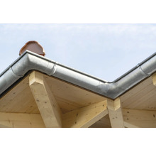 Verzinkte Dachrinne montiert an einer Dachkonstruktion aus Holz mit sichtbaren Dachziegeln.