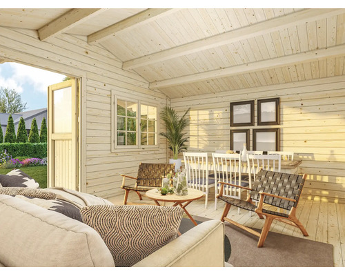 Heller Innenraum eines Gartenhauses aus hellem Holz mit Sofa, geflochtenen Sesseln, Esstisch und Blick in den Garten durch eine offene Tür.