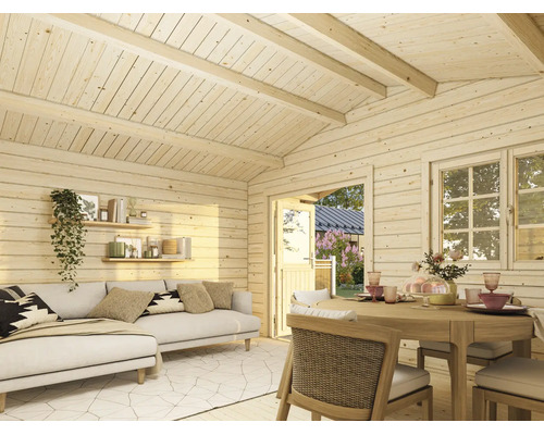 Innenansicht eines hellen Gartenhauses aus Holz mit Wohnbereich, Sofa, Esstisch und Blick in den Garten durch Tür und Fenster.