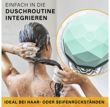 Person beim Haarewaschen in einer hellen Dusche, mit einer Detailansicht eines geometrisch geformten Abflusssiebs gegen Haare und Seifenrückstände.