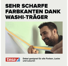 Ein Mann zieht tesa Malerband mit Washi-Träger von einer Wand ab, um eine scharfe Farbkante zu erzeugen. tesa Logo.