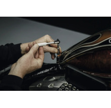 Eine Hand nutzt eine Mini-Umschaltknarre für Arbeiten an einem Motorrad.