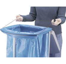 Person befestigt einen blauen Müllbeutel mit einer Schnur an einem Abfallsammler aus Metall.