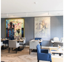 Restaurant mit gemusterter Tapete in Wabenform, Holzboden in Fischgrätmuster, gepolsterten Stühlen und zwei großen Wandgemälden in modernem Stil.