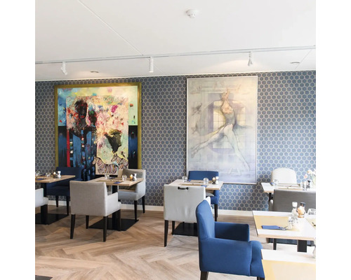 Restaurant mit gemusterter Tapete in Wabenform, Holzboden in Fischgrätmuster, gepolsterten Stühlen und zwei großen Wandgemälden in modernem Stil.