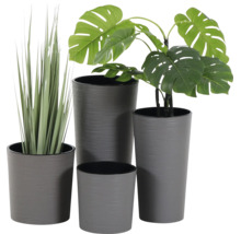 Set aus vier grauen Kunststoff-Blumentöpfen in verschiedenen Größen mit Rillenstruktur, bestückt mit einer Monstera-Kunstpflanze und Kunstgras.