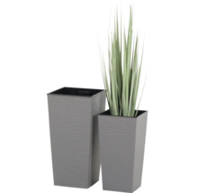 Zwei hohe, graue, quadratische Pflanzkübel mit horizontal gerillter Oberfläche, einer davon mit Kunstgras bepflanzt.