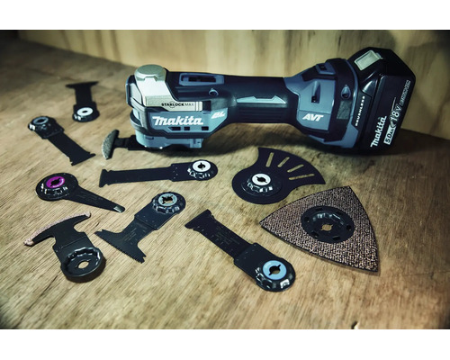 Makita Akku-Multitool mit verschiedenen Starlock-Aufsätzen wie Sägeblättern und Schleifplatte auf einer Holzoberfläche.