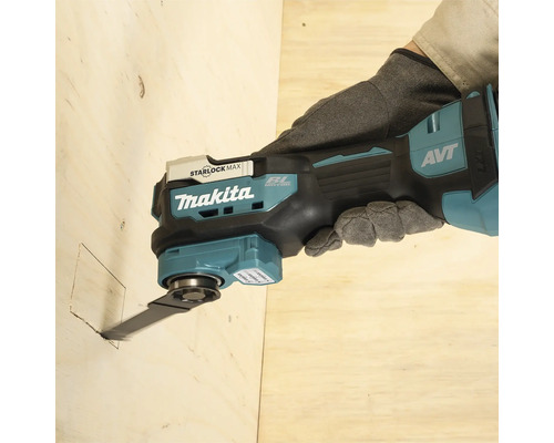 Makita Akku-Multitool schneidet mit einem Tauchsägeblatt eine quadratische Öffnung in eine Holzplatte.