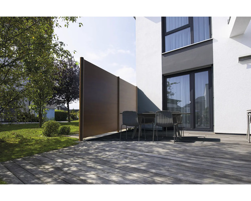 Moderne Terrasse mit Holzdeck, Gartenmöbeln und einem braunen Sichtschutz aus WPC-Elementen neben einer weißen Hauswand.