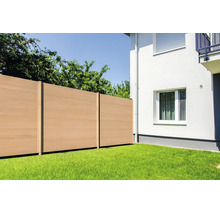 Moderner Sichtschutzzaun aus Wood-Plastic-Composite in Holzoptik, im Garten auf einem Rasen neben einer weißen Hauswand installiert.