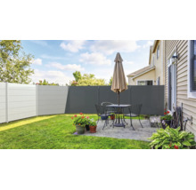 Moderner Sichtschutzzaun aus Kunststoff in verschiedenen Grautönen auf einer gepflegten Terrasse mit Sitzgruppe, Sonnenschirm und Pflanzen.