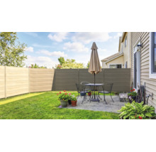 Moderner Sichtschutzzaun aus horizontalen Paneelen in einem Garten mit Terrasse, Sitzgruppe und Sonnenschirm auf gepflegtem Rasen.