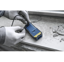 Eine Person mit Arbeitshandschuhen schließt ein USB-Kabel an ein Feuchtigkeitsmessgerät an.