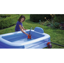 Eine Frau entleert einen aufblasbaren Pool im Garten mit einer Akku-Tauchpumpe von Einhell.