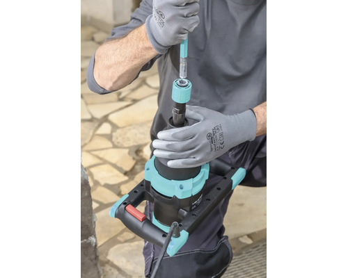 Handwerker montiert einen Rührstab in die Schnellkupplung eines elektrischen Rührgeräts.