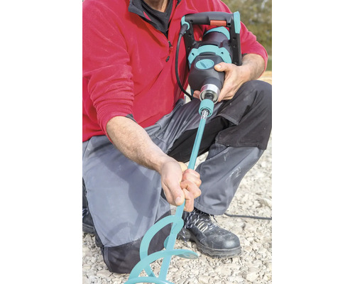 Ein Handwerker setzt einen Rührstab in ein elektrisches Farb- und Mörtelrührwerk ein.