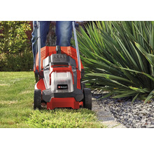 Einhell Akku-Rasenmäher beim präzisen Mähen einer Rasenkante an einem Beet im Garten.