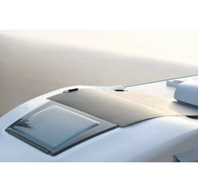 Flexibles Solarmodul, das auf dem geschwungenen Dach eines Wohnmobils neben einer Dachluke montiert ist.