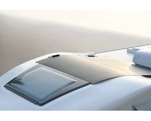 Flexibles Solarmodul, das auf dem geschwungenen Dach eines Wohnmobils neben einer Dachluke montiert ist.