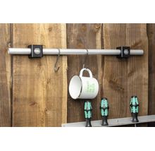 Aluminiumrohr mit zwei schwarzen Haltern an einer Holzwand montiert, mit S-Haken und einer Tasse.