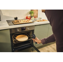 Person misst mit einem Bosch Thermodetektor die Temperatur eines Pizzasteins in einem Backofen in einer modernen Küche.