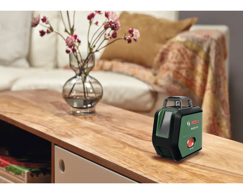 Bosch PLL 360 15G Kreuzlinienlaser auf einem Holztisch im Wohnzimmer stehend
