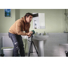 Ein Handwerker verwendet einen Bosch Kreuzlinienlaser auf einem Stativ, um in einem Badezimmer Messungen vorzunehmen.