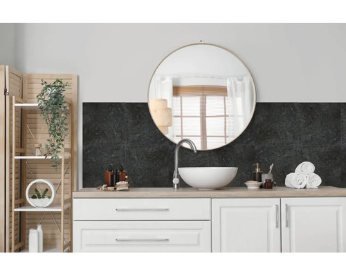 Modernes Badezimmer mit Waschtisch, weißem Aufsatzwaschbecken, rundem Spiegel und dunkler Wandverkleidung mit Steinoptik als Fliesenspiegel.