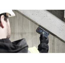 Handwerker misst die Neigung einer Betonkonstruktion mit einem Bosch Laser Neigungsmesser auf einer Baustelle.