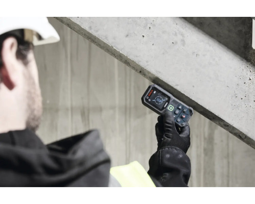 Handwerker misst die Neigung einer Betonkonstruktion mit einem Bosch Laser Neigungsmesser auf einer Baustelle.