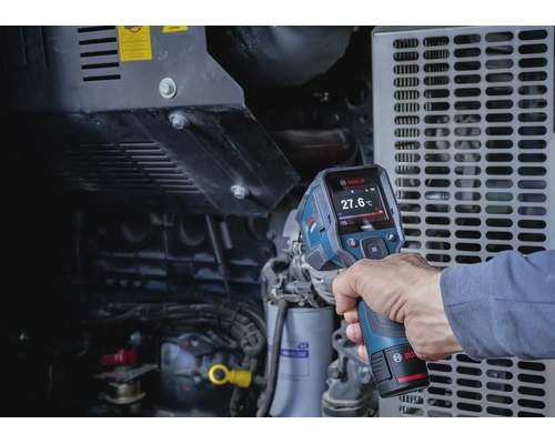 Eine Hand hält eine Bosch Wärmebildkamera, die die Temperatur eines Maschinenmotors misst.