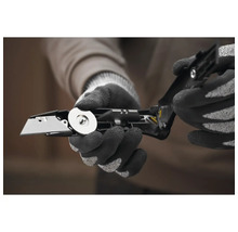 Person mit Handschuhen beim Öffnen eines Klappmessers mit auswechselbarer Klinge