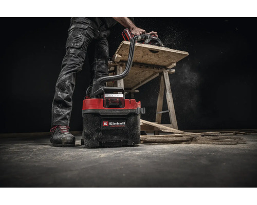 Einhell Akku Nass Trockensauger im Einsatz mit einer Handkreissäge bei der Holzbearbeitung auf einer Werkbank.