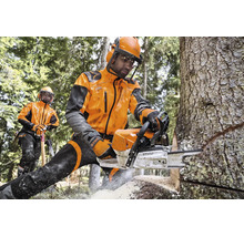 Forstarbeiter in Stihl Schutzkleidung sägen Baumstamm mit Stihl Motorsäge im Wald.
